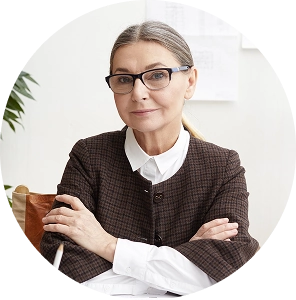 Zakelijke vrouw met bril zit met gekruiste armen in een kantooromgeving, passend bij de financiële sector.