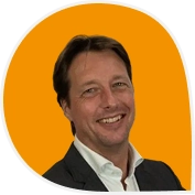 Portret van een lachende man in pak voor een oranje achtergrond, getiteld "Review-image-Larren (1)".